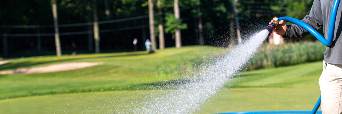 man spraying water on a golf course